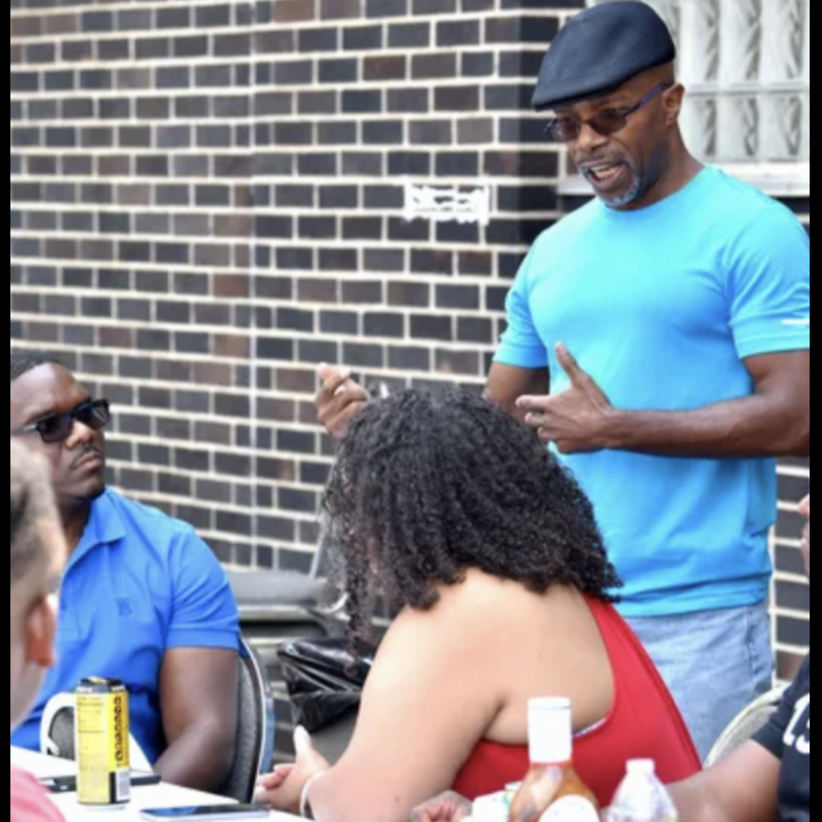 Darrell Siggers speaking with community members at an outdoor gathering